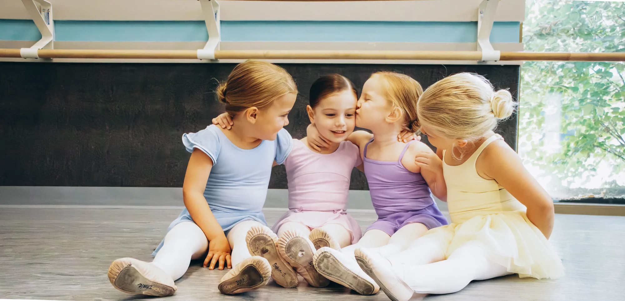 Young Snowflake Spectacular dancers sitting together during a winter camp moment at Miller Street Dance Academy